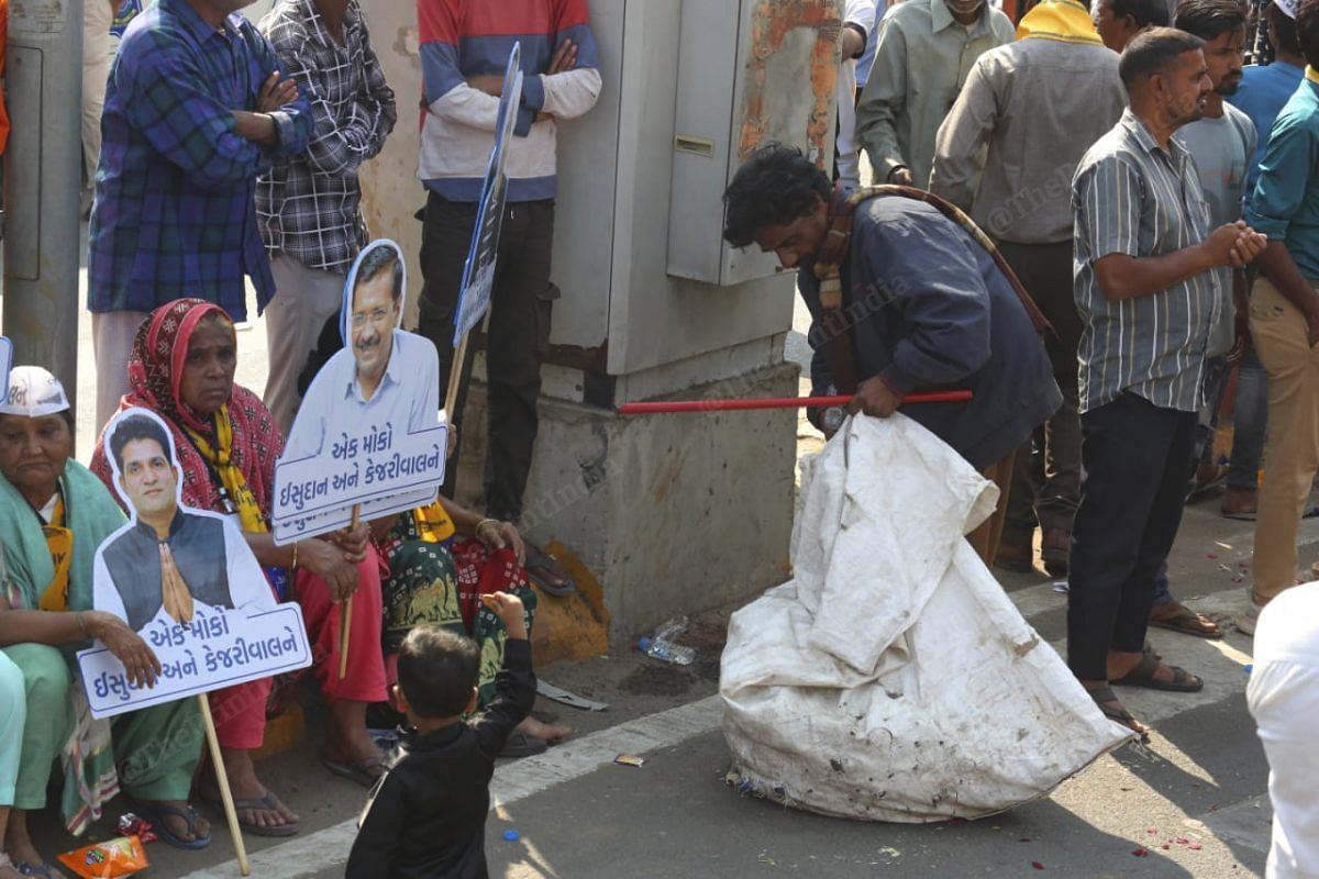 A ragpicker collects empty bottles and pamphlets at the roadshow | Photo: Praveen Jain | ThePrint 