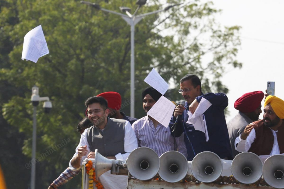 AAP national convener tosses copies of electricity bills from Punjab households | Photo: Praveen Jain | ThePrint