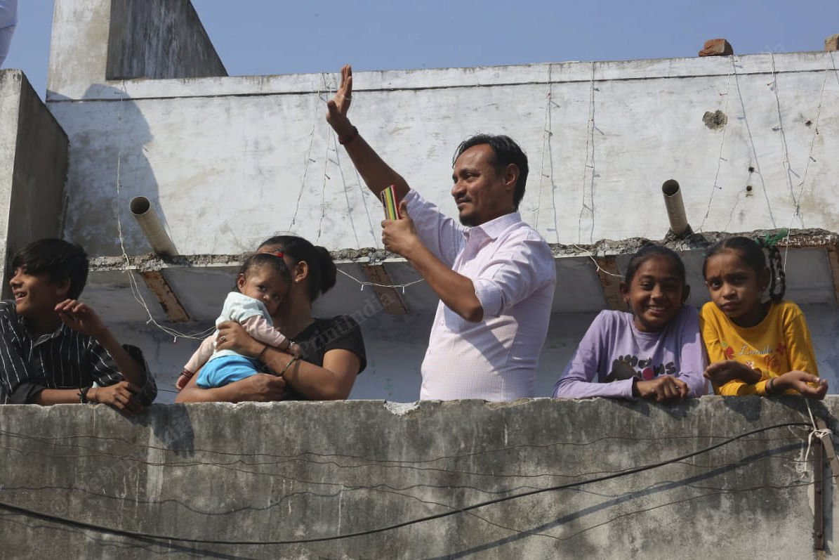 A family watches the procession go past their house | Photo: Praveen Jain | ThePrint