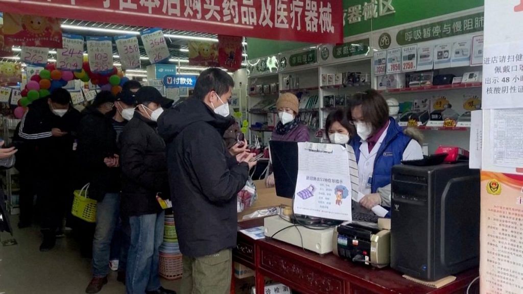 People stand in a queue to purchase medicines at a pharmacy in Beijing, China December 14, 2022, in this screen grab taken from a Reuters TV video. REUTERS TV via REUTERS/File Photo
