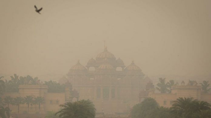 A bird flies next to the smog-covered Akshardham temple in New Delhi, India| Photo: Reuters File | Adnan Abidi