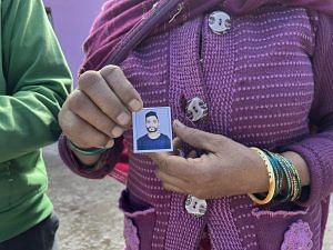 Sumit Kumar's mother holding his passport photo which he used to attach in various recruitment forms | Jyoti Yadav, ThePrint