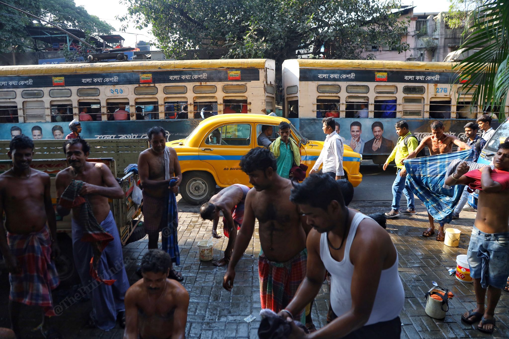 December 2022: Trams in Kolkata are dying, but these caterpillar joy rides still have a fanbase. Women find them safe and full of adventure, kids have their fun and the elderly see them as comfortable. Kolkata gets its much-praised vibe from trams. In this photo, a tram passes a busy street, where men are seen using the public bath on the sides. It defines the chaos and beauty of the city that loves the slowness life has to offer | Manisha Mondal, ThePrint