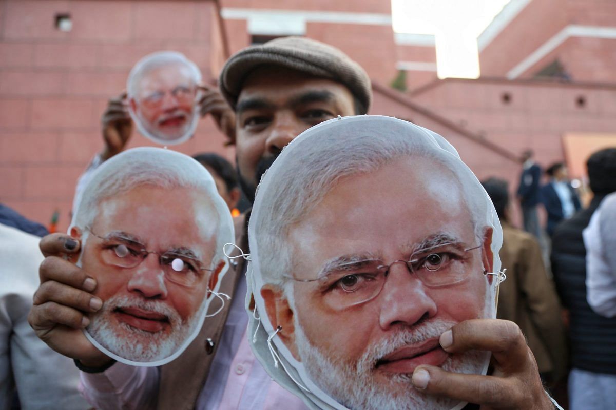 A BJP supporter poses with Modi masks | Photo: Manisha Mondal | ThePrint