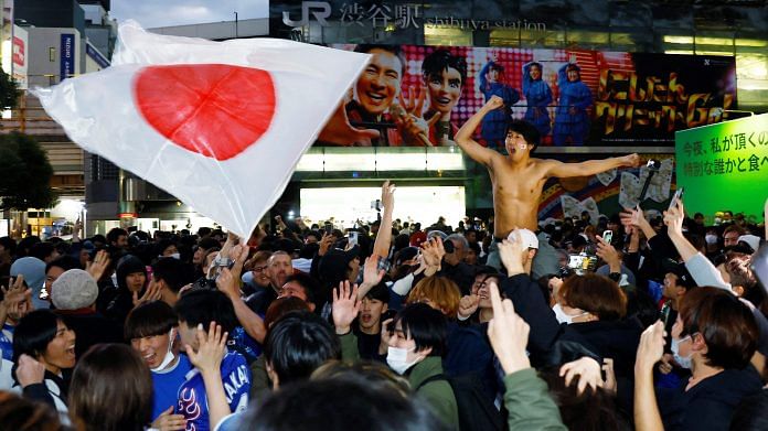 Japan fans celebrate at the Shibuya Crossing after the match as Japan qualify for the knockout stages on, 2 December 2022