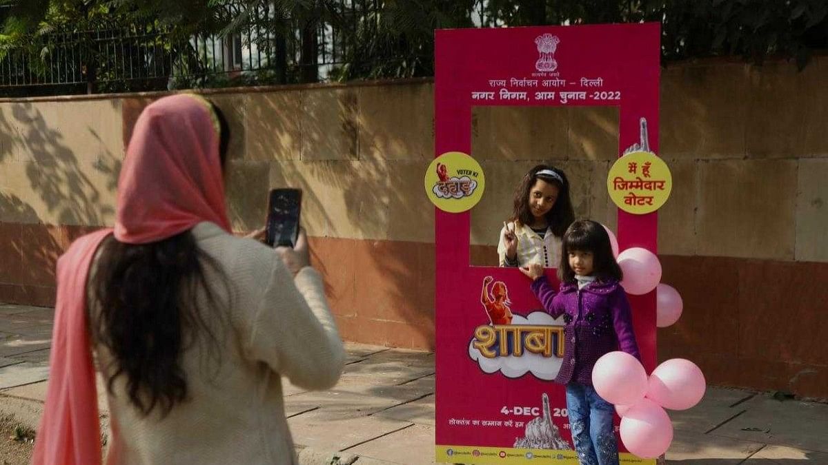 A woman and her daughters click photos at selfie booth outside Sarvodaya Bal Vidyalaya | Manisha Mondal | ThePrint