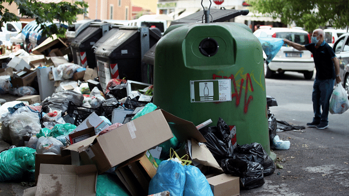 A man throws a garbage bag at a full rubbish bin, in Rome 25 June, 2021 | Reuters/Yara Nardi/File Photo