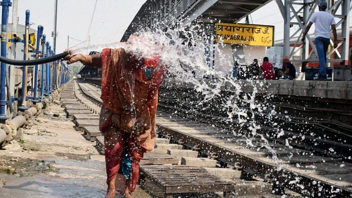 Representational image | A woman splashes water on her face from a pipe on a hot summer day, at the Prayagraj railway station | ANI Photo