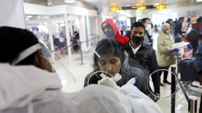 File photo of a healthcare worker collecting a COVID-19 test swab sample at the Indira Gandhi International Airport in New Delhi, India, on 3 December, 2021 | Reuters