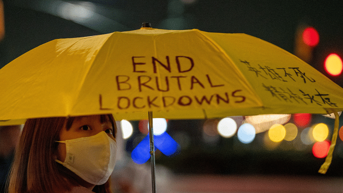 A person holding an umbrella with a slogan on it takes part in anti-Chinese government protests, amid China's 'zero-COVID' policy, near the Chinese consulate in New York City | Reuters/David 'Dee' Delgado