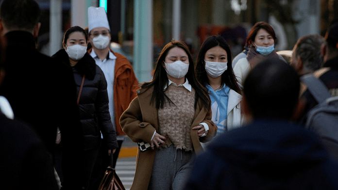 People wearing masks cross a street, as coronavirus disease outbreaks continue in Shanghai, China | Reuters File Photo/Aly Song