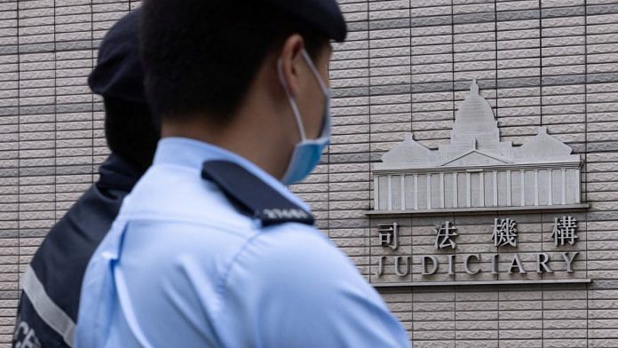 Police stands guard outside the West Kowloon Magistrates' courts in Hong Kong, China 25 November 2022 | Reuters/Tyrone Siu