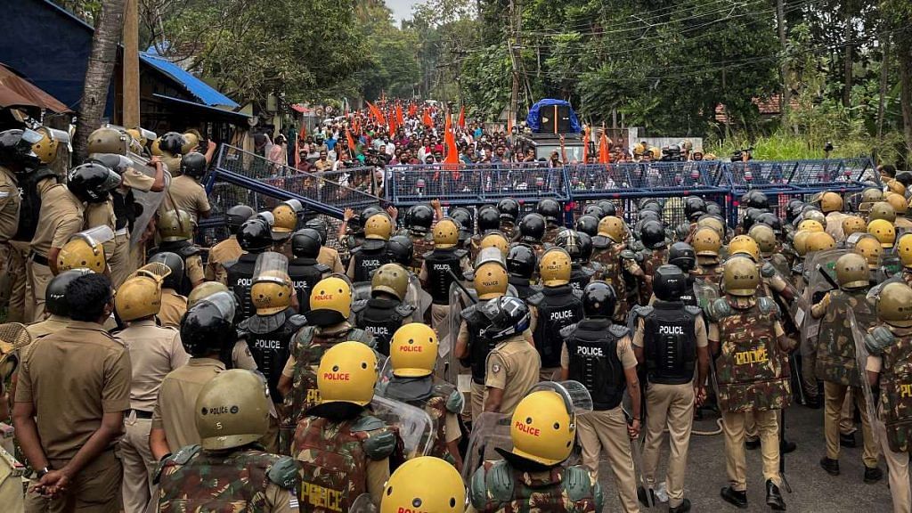 Police officers stand guard near the barricades during a protest rally by the supporters of the proposed Vizhinjam port project in Kerala, on 30 November 2022 | Reuters