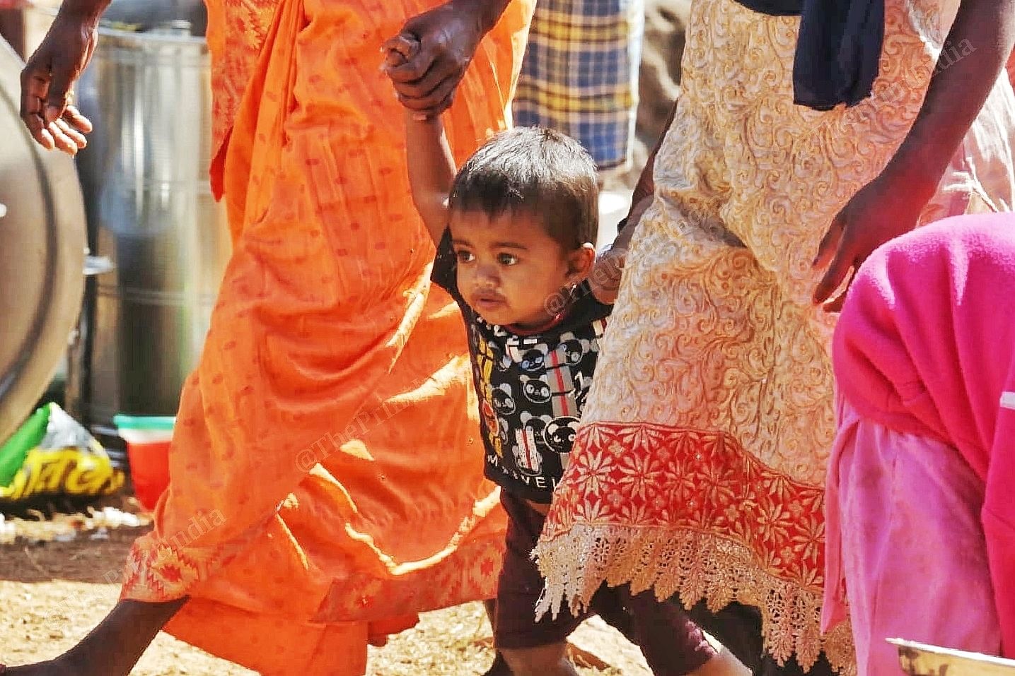 A toddler is led away by family members | Photo: Praveen Jain | ThePrint