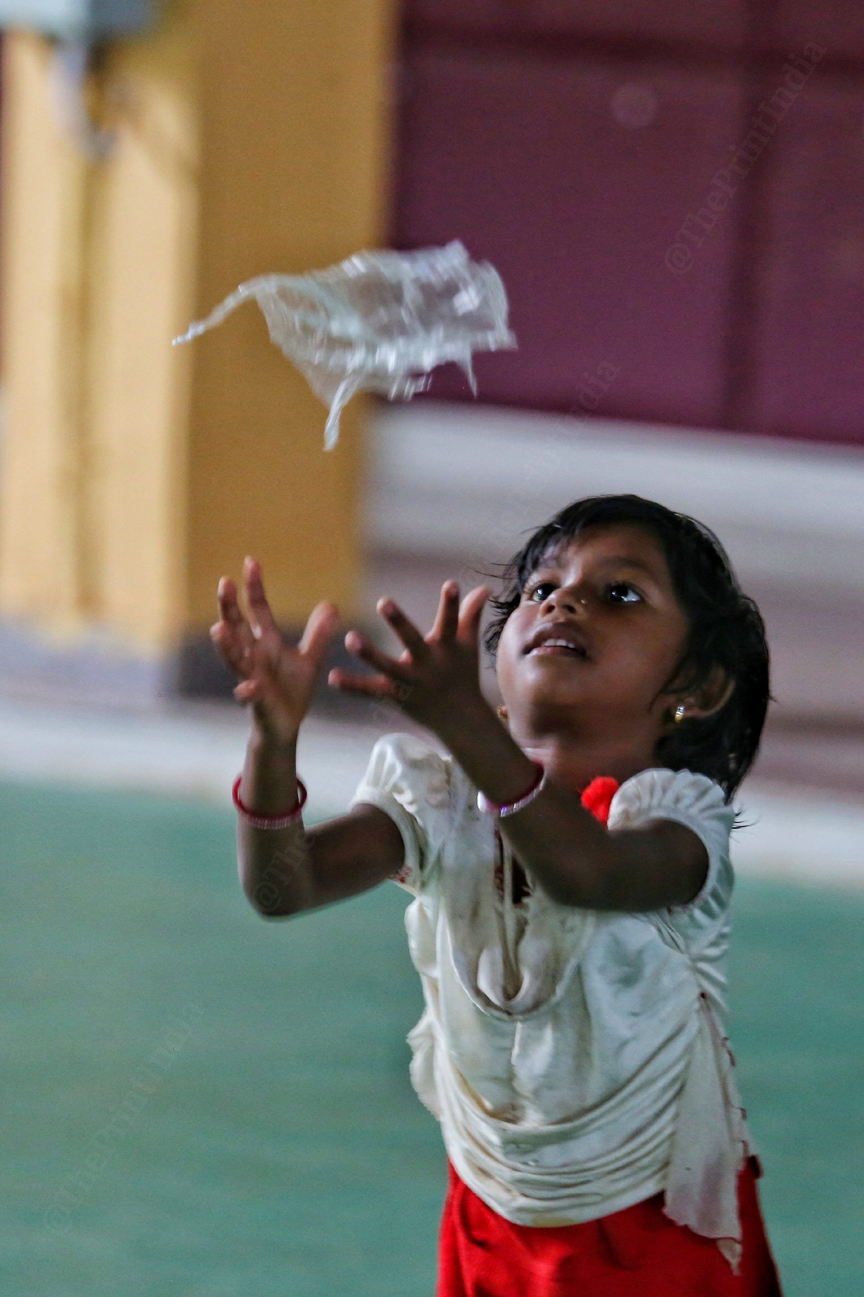 A girl plays with a discarded packet of drinking water | Photo: Praveen Jain | ThePrint
