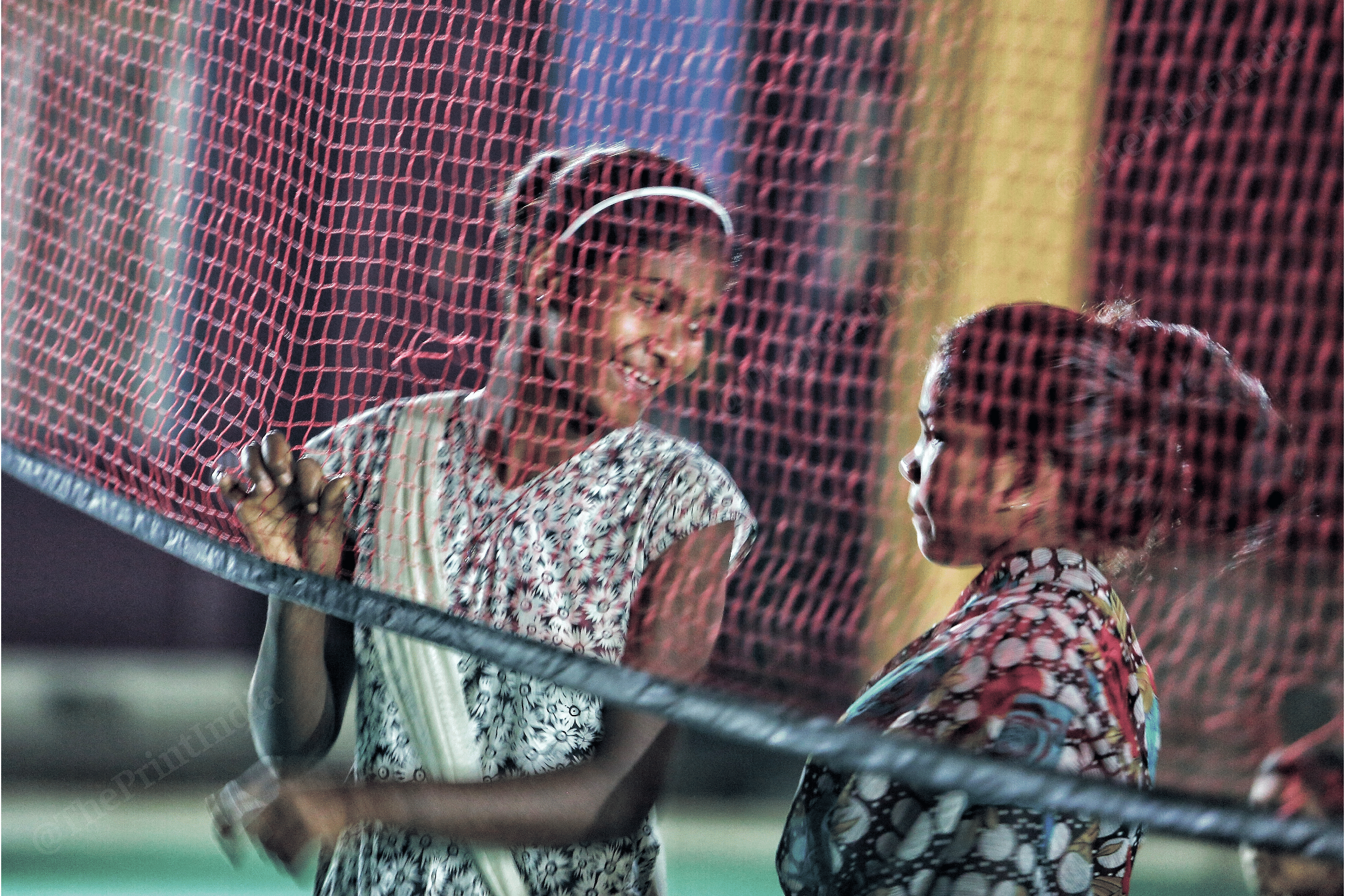 Confidences are exchanged by a volleyball net inside the stadium | Photo: Praveen Jain | ThePrint