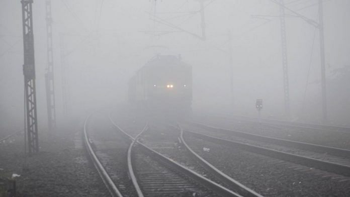 A train runs on the track amid dense fog on a cold winter morning, in Prayagraj on Sunday | ANI