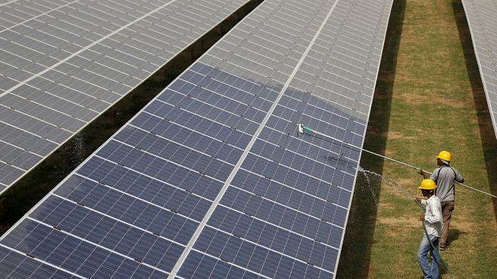 File photo of workers cleaning photovoltaic panels inside a solar power plant in Gujarat, India, on 2 July, 2015 | Reuters