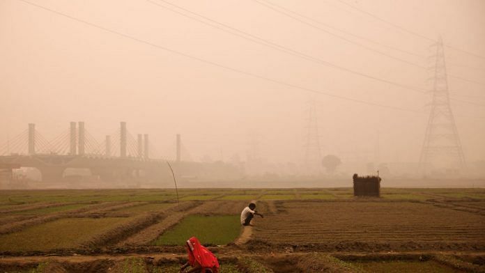 File photo of farmers working amidst smog in a field on the bank of the Yamuna river in New Delhi, India, on 8 November, 2022 | Reuters