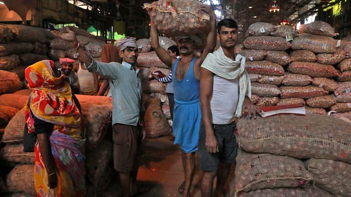 File photo of a labourer carrying a sack of onions at a wholesale market in Kolkata, India, on 14 December, 2021 | Reuters