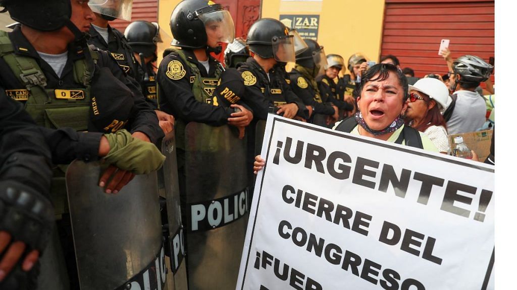 A demonstrator holds a sign reading "Urgent! The closure of the Congress" in Lima, Peru on Saturday | Reuters