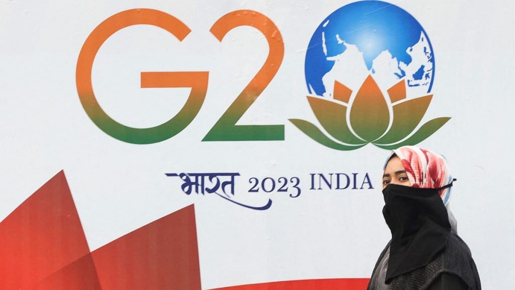 A woman walks past a hoarding of India's G20 presidency, on a street in Mumbai | Reuters file photo