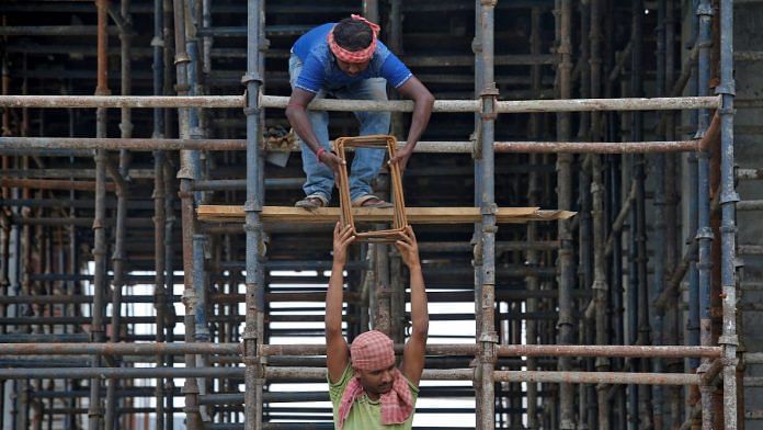 Labourers work at the construction site of a residential building on the outskirts of Kolkata | Reuters