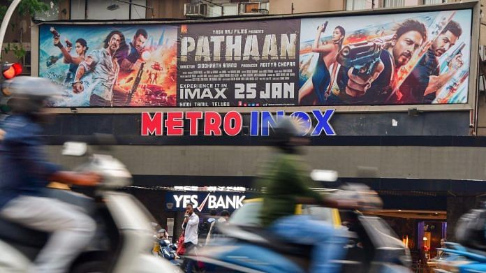 A vehicles passes by a poster of the Bollywood film Pathaan put up at the Metro theatre in Mumbai, on 24 January 2023 | PTI