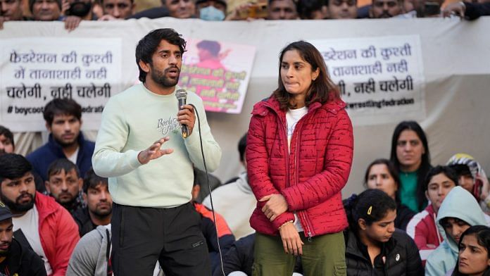 Wrestler Bajrang Punia speaks as fellow wrestler Vinesh Phogat looks on during their ongoing protest against the Wrestling Federation of India (WFI), at Jantar Mantar in New Delhi, on 20 January 2023 | PTI