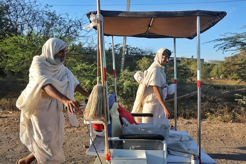 Sadhu Bhagyaratna Vijay with a Jain monk who is using a wheelchair to carry his belongings. Elderly or injured monks use such assistance to recover from their conditions, without stalling the Vihar | Praveen Jain | ThePrint