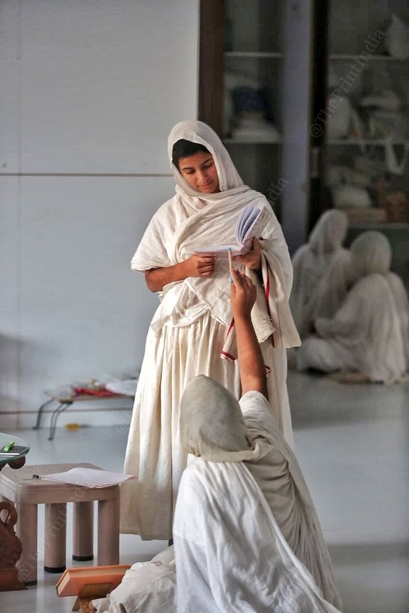 Sadhvi Asangpragnya, 29, discusses a Jain religious text with another nun at a upasraye in Surat | Praveen Jain | ThePrint