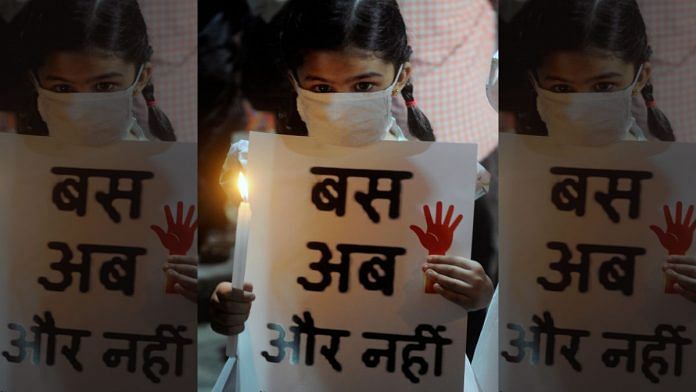 A child holds a candle and placard during a protest over Hathras gang-rape in Kolkata | ANI file photo