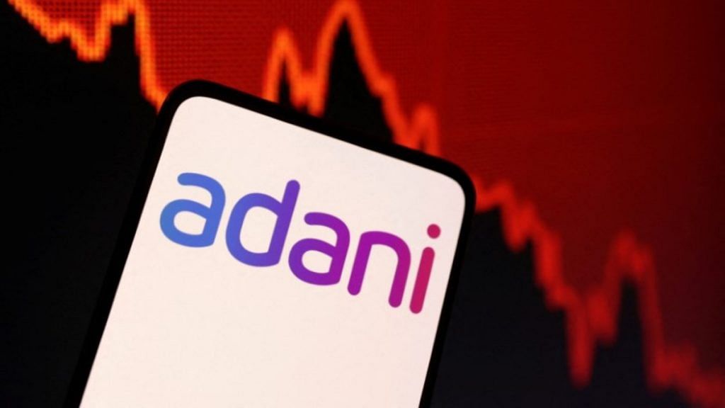 Adani logo and decreasing stock graph is seen in this illustration | Reuters