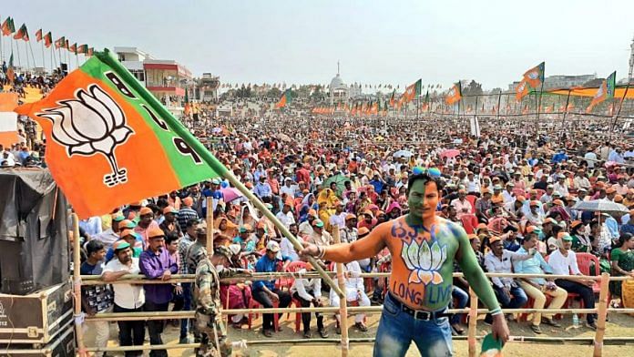 A BJP supporter waves the party flag at a rally | Representational image | ANI