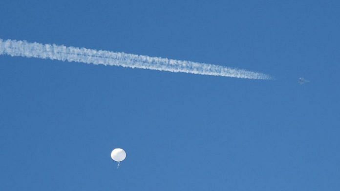 A jet flies by a suspected Chinese spy balloon as it floats off the coast in Surfside Beach, South Carolina, US on 4 February, 2023 | Reuters