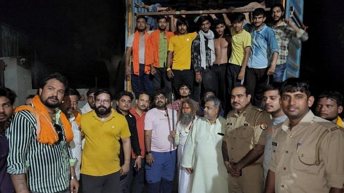 Monu Manesar (centre, in pink T-shirt) poses with gau rakshaks and policemen in a photo posted on his Facebook last May | Facebook/Monu Manesar