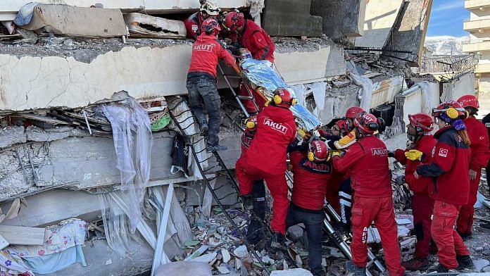 Rescuers carry a woman after she was evacuated from under a collapsed building following an earthquake in Kahramanmaras, Turkey, on 7 February 2023 | Reuters