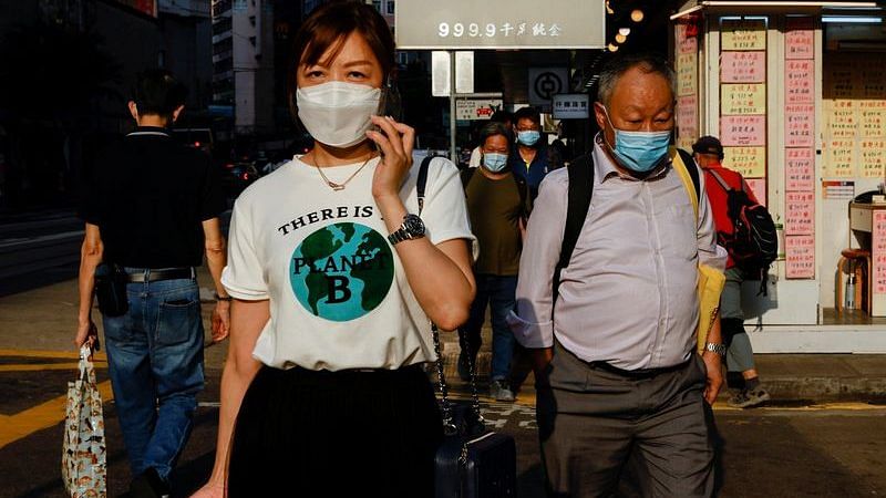 People wearing face masks walk through Wan Chai during the Covid-19 pandemic in Hong Kong, China, on 14 April, 2022 | File Photo: Reuters