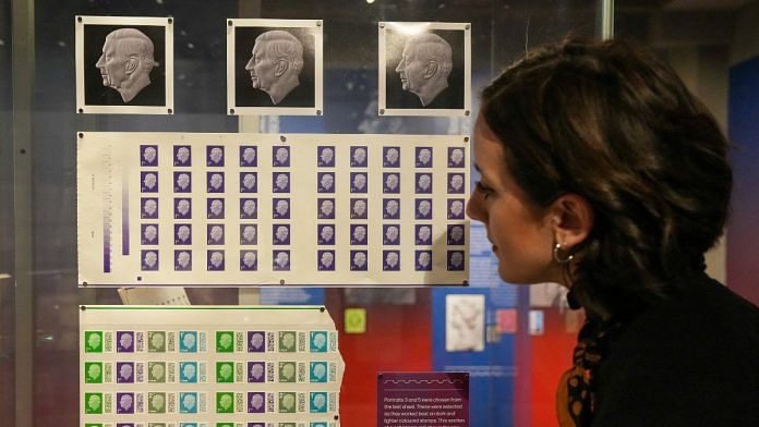 A Postal Museum employee looks at the new definitive stamps depicting Britain's King Charles, unveiled by the Royal Mail, in London, on 7 February 2023 | Reuters/Maja Smiejkowska