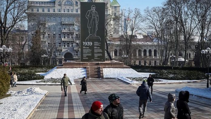 People walk in a park near the monument of Ukrainian poet Taras Shevchenko covered with a protective construction to protect against shelling, amid Russia's invasion, in central Kyiv, Ukraine on 8 February, 2023 | Reuters