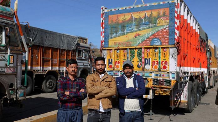 Truck drivers Lal Singh, Vijay Mehra and Tilak Raj pose for a picture near parked trucks next to the Ambuja Cements Limited plant owned by Adani Group in Darlaghat, Solan district in Himachal Pradesh on 16 February | Reuters