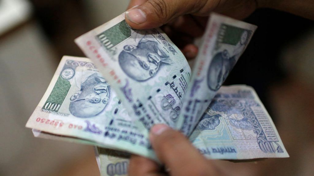An employee counting Indian rupee currency notes inside a private money exchange office in New Delhi | Reuters file photo