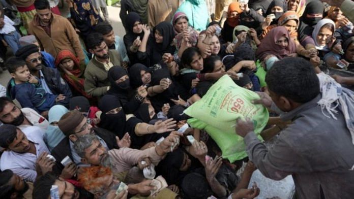 Pakistani people gather to buy subsidized sacks of flour from a sale point in Karachi, Pakistan | PTI