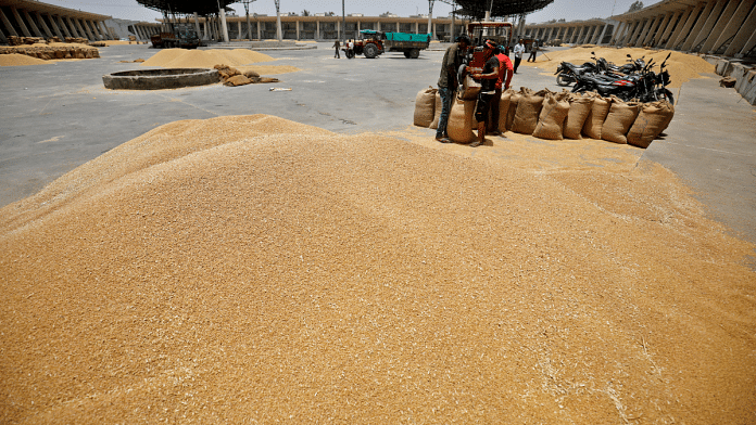 Workers fill sacks with wheat at the market yard of the Agriculture Product Marketing Committee (APMC) on the outskirts of Ahmedabad | Reuters/Amit Dave/File Photo