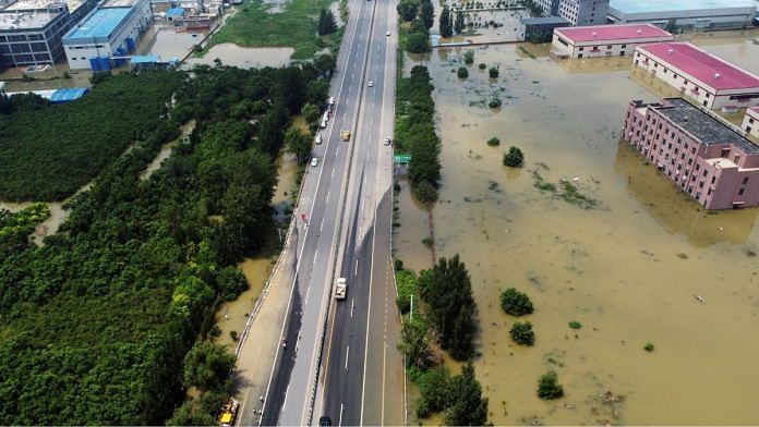 File photo of an aerial view showing flooded industrial buildings by a highway following heavy rainfall in Xinxiang, Henan province, China on 4 July, 2021 | Reuters