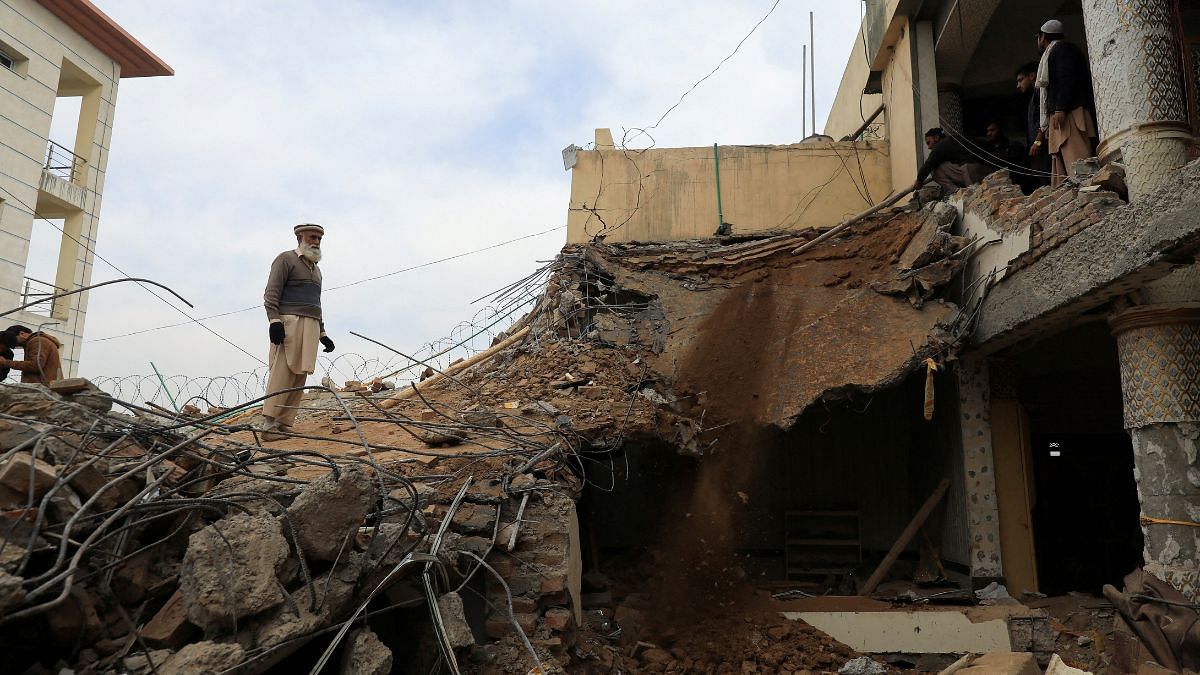 Untitled design (82) File photo of a man standing amid a damaged structure, days after a suicide blast in a mosque in Peshawar, Pakistan 1 February, 2023 | Reuters