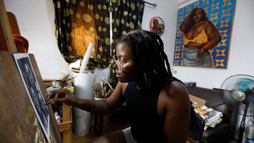 Chigozie Obi, 25-year-old artist and first-time voter, creates an artwork in her studio in Lagos, Nigeria on 15 February, 2023 | Reuters