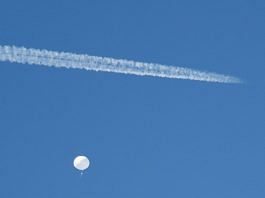 A jet flies by a suspected Chinese spy balloon as it floats off the coast in Surfside Beach, South Carolina, on Saturday | Reuters