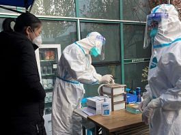 A medical worker in a protective suit registers information for a patient at the entrance to the fever clinic of the Central Hospital of Wuhan | Reuters file photo