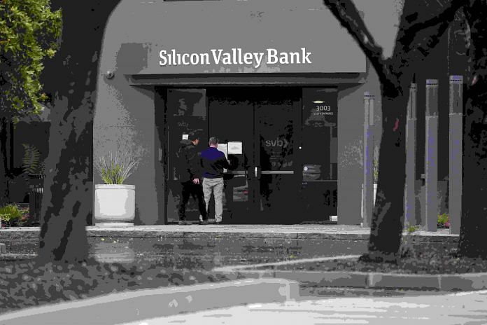 File photo of a man putting up a sign on the door of the Silicon Valley Bank as an onlooker watches at the bank’s headquarters in Santa Clara, California, US | Reuters